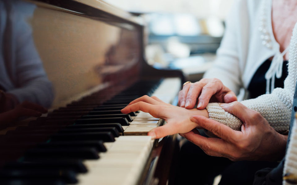 Piano teacher giving piano lesson to student